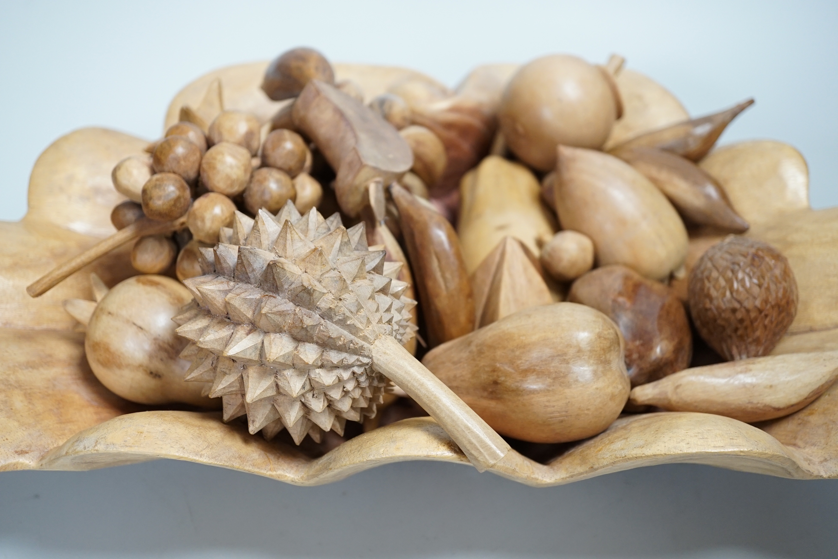A carved wood bowl and fruit